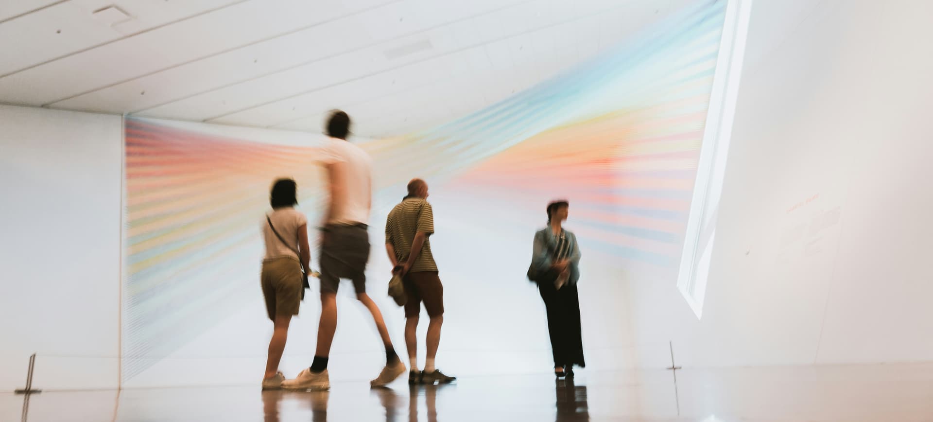 Visitors viewing rainbow art installation in museum